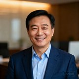 一位45岁左右的中国男性企业家头像，穿着深蓝色西装搭配浅蓝衬衫，面带自信微笑，背景为柔和的办公室虚化场景。